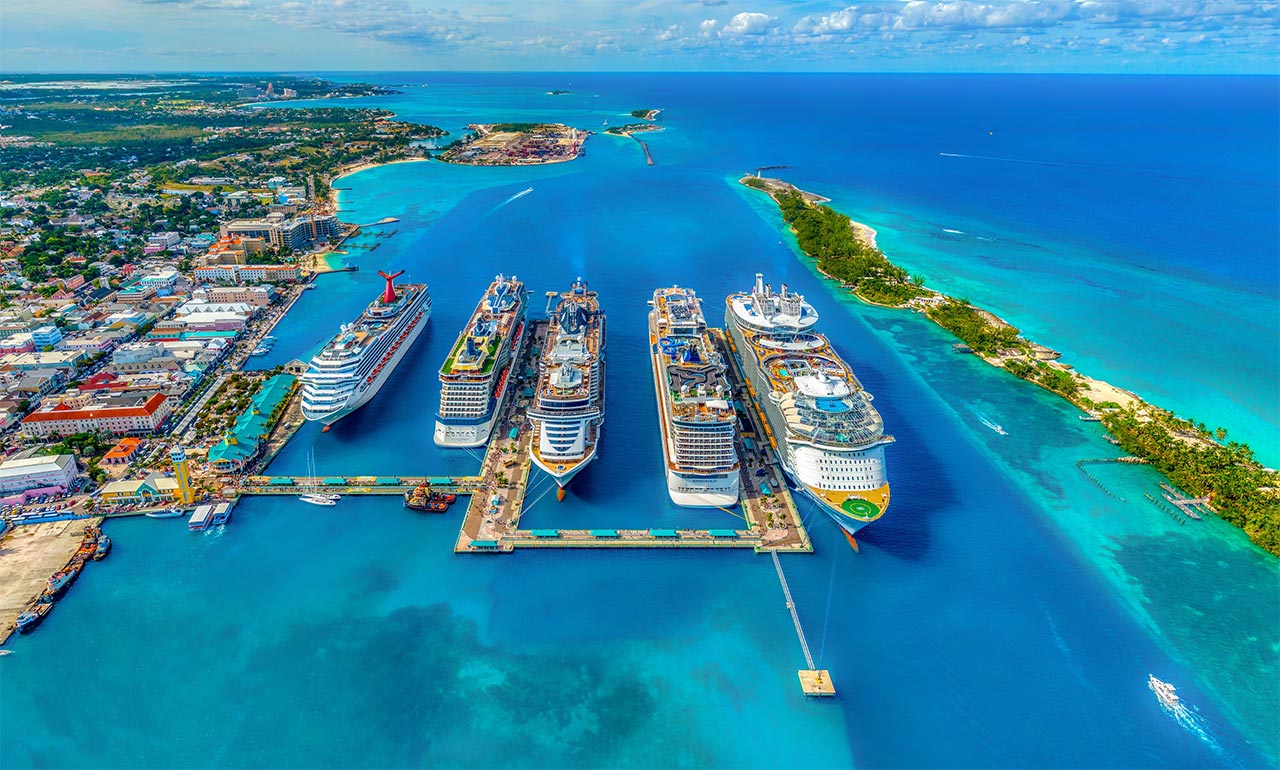 How to Become a Cruise Travel Agent Cruise ships docked in The Bahamas.