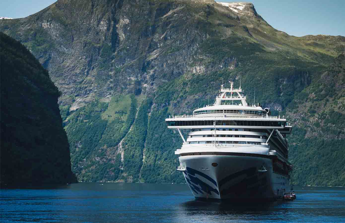 Princess cruise ship with mountains in background.