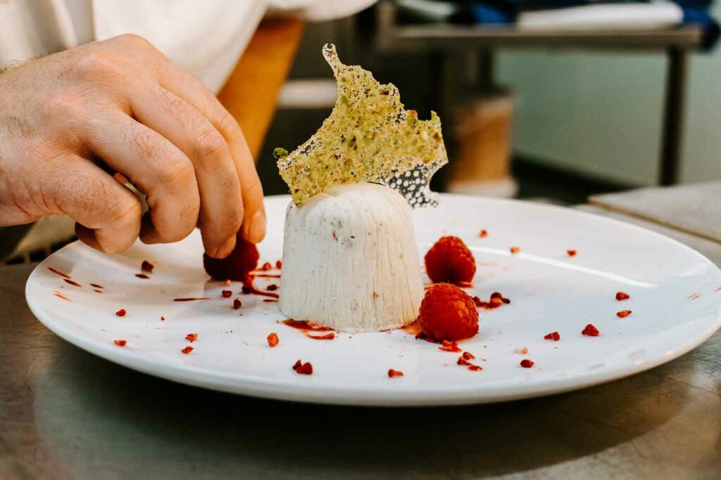 Chef placing the final raspberry for a dessert.
