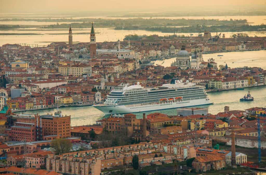 Cruise ship sailing through Venice at sunset.
