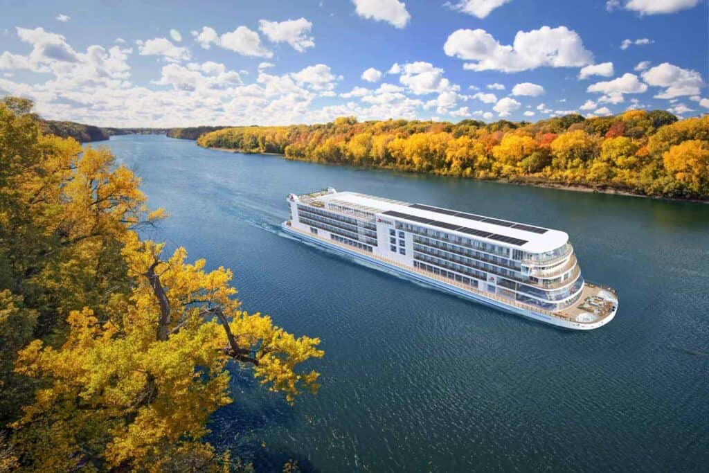 River cruise ship sailing down the Mississippi river on an autumn day.