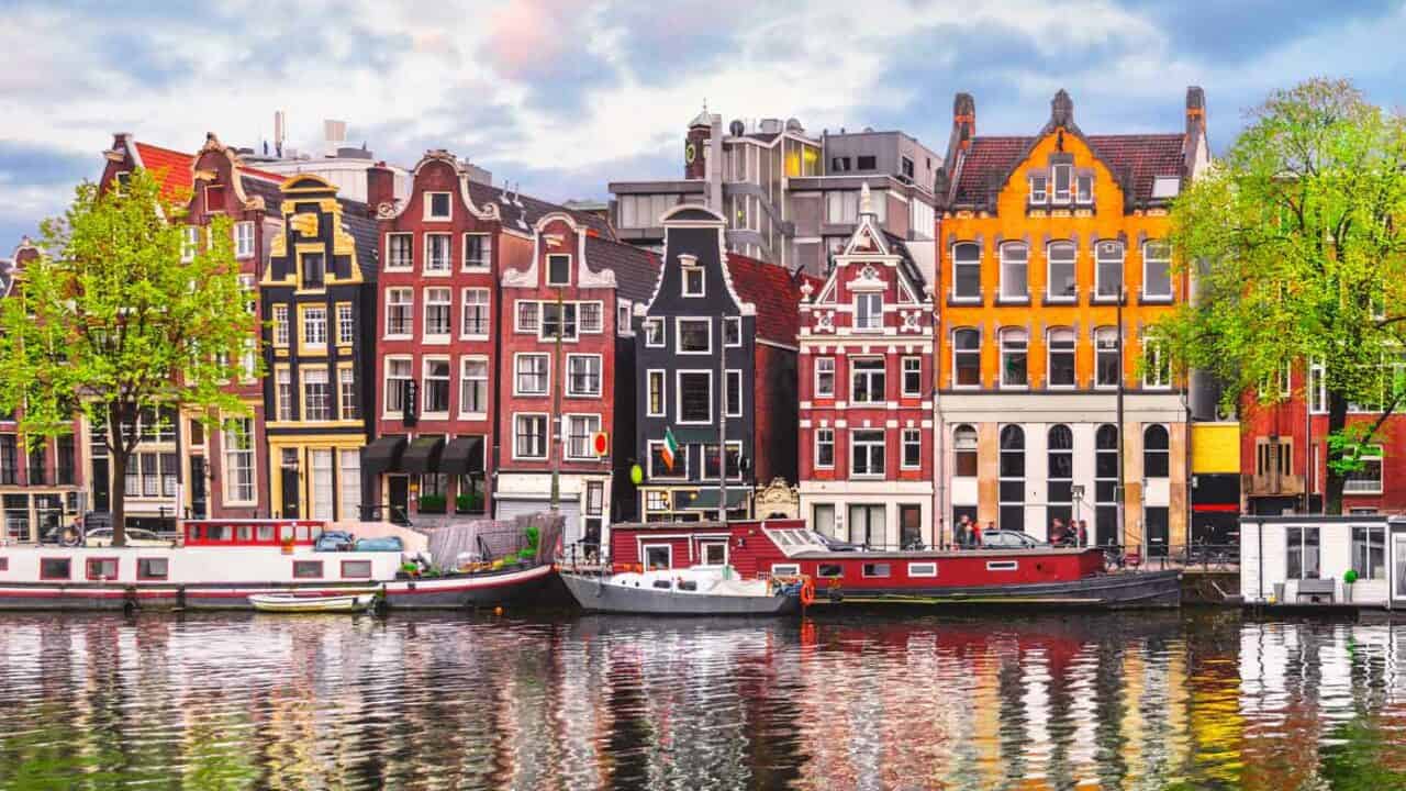 Colorful European houses lining the Amstel River in Amsterdam, Netherlands.