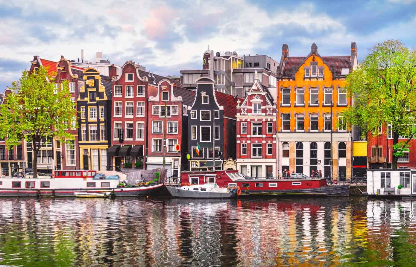 Colorful European houses lining the Amstel River in Amsterdam, Netherlands.