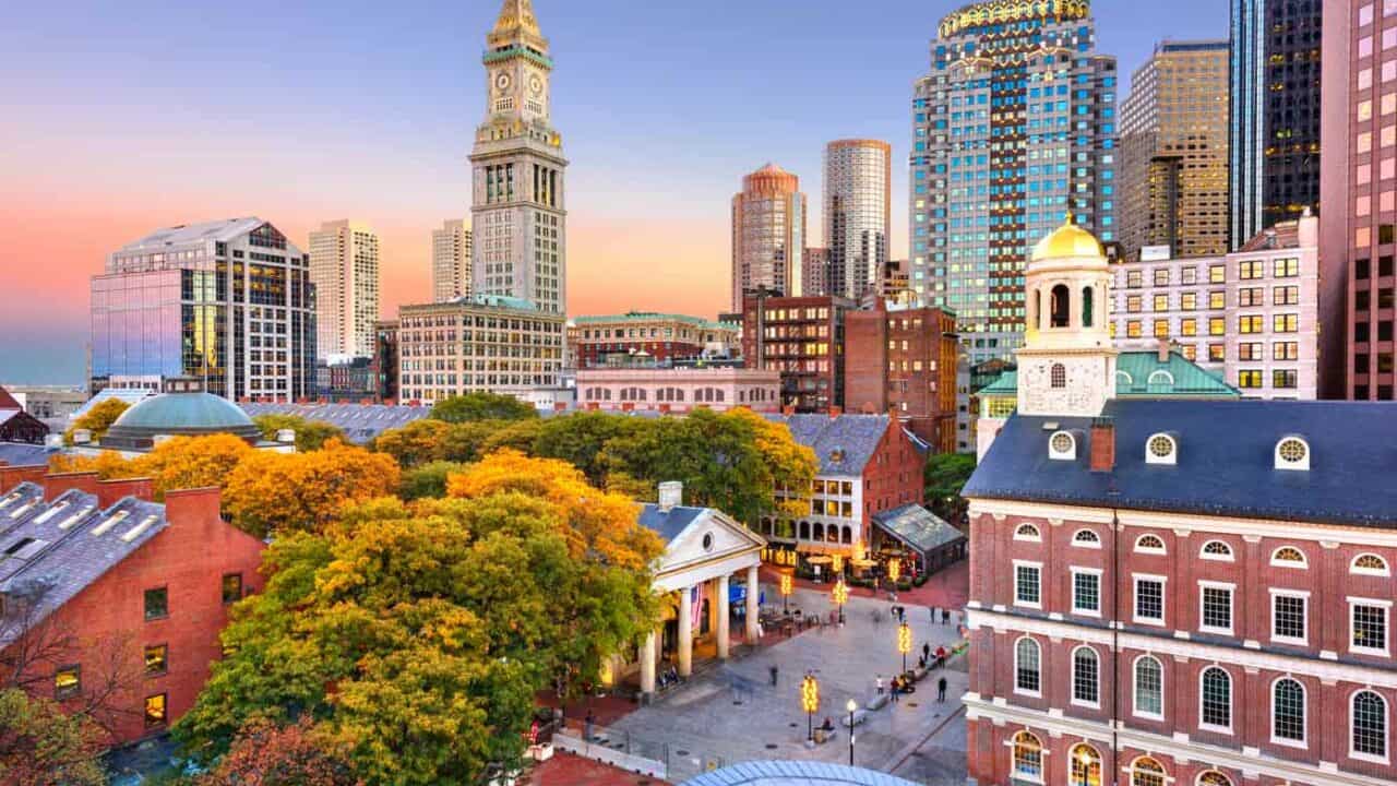 Skyline of Boston Massachusetts including Faneuil Hall and Quincy Market at dusk.