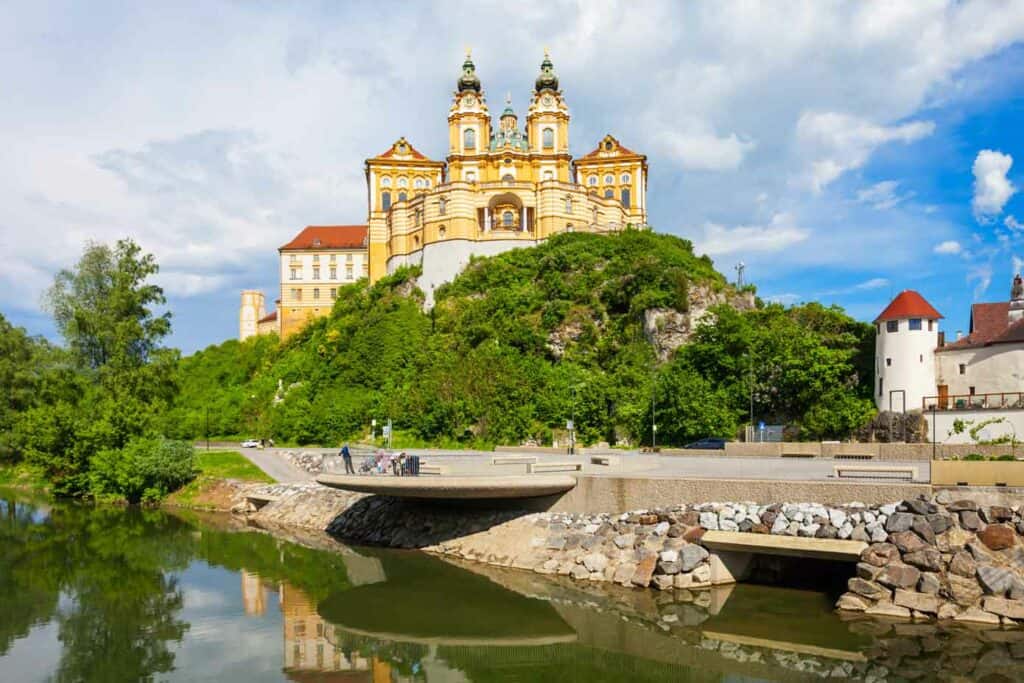 Melk Abbey Monastery on a rocky outcrop overlooking the Danube River on a sunny day.
