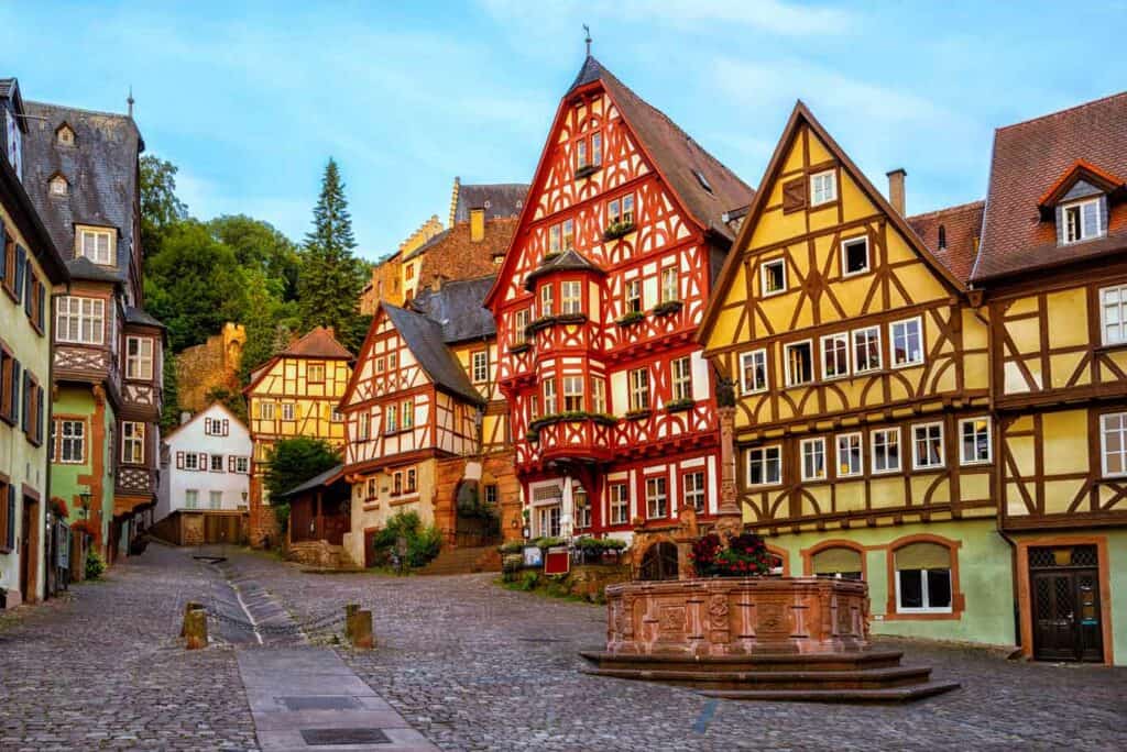 Colorful half-timbered houses on a cobblestone street in Bavaria, Germany.