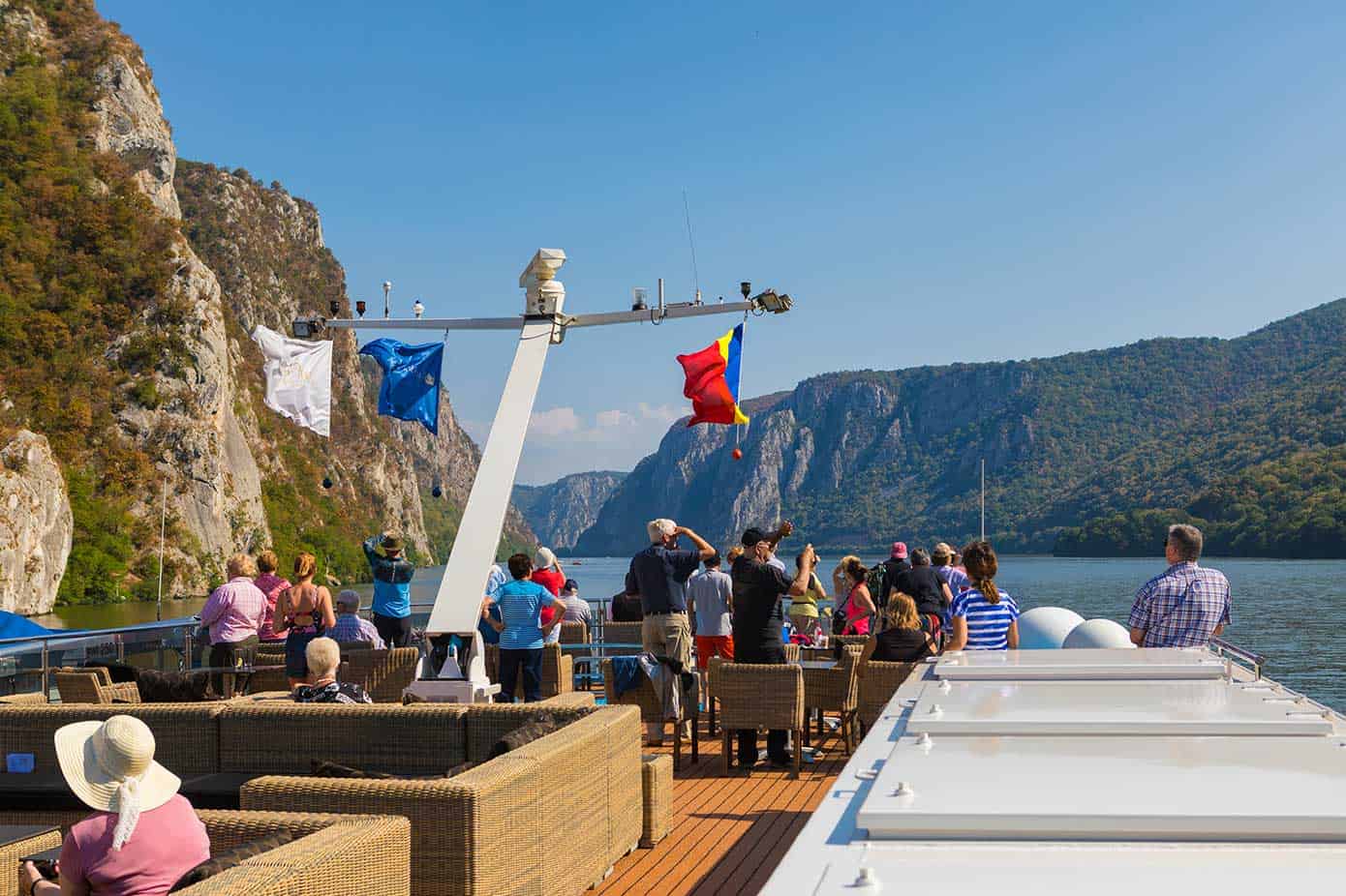 People on a river cruise ship taking pictures of large the Iron Gates gorge on the Danube River.