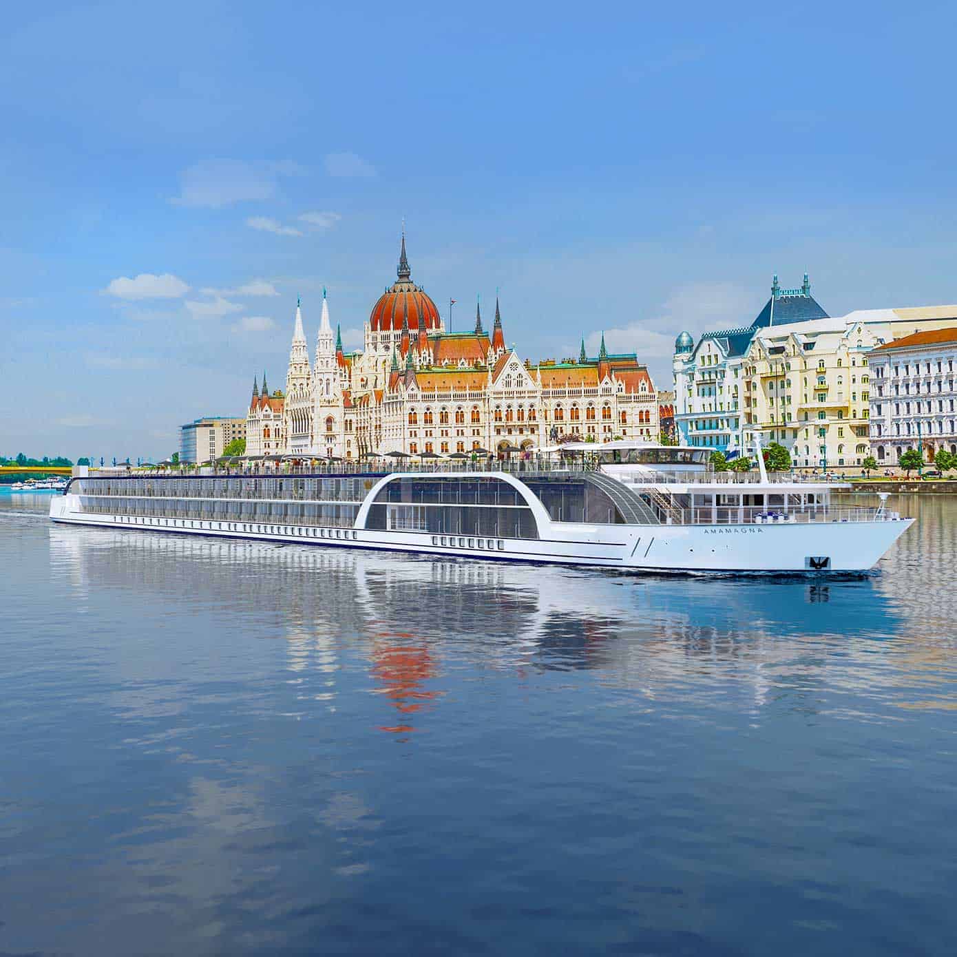 Exterior view of a river cruise ship with a historic city in the background.