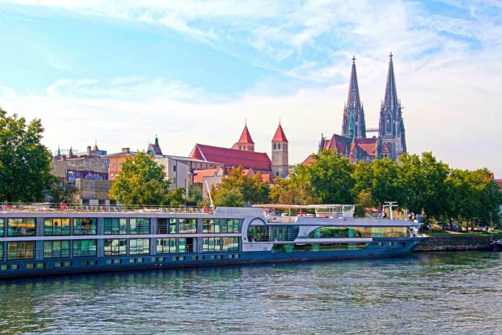 River cruise ship on the Danube River with a castle in the background.