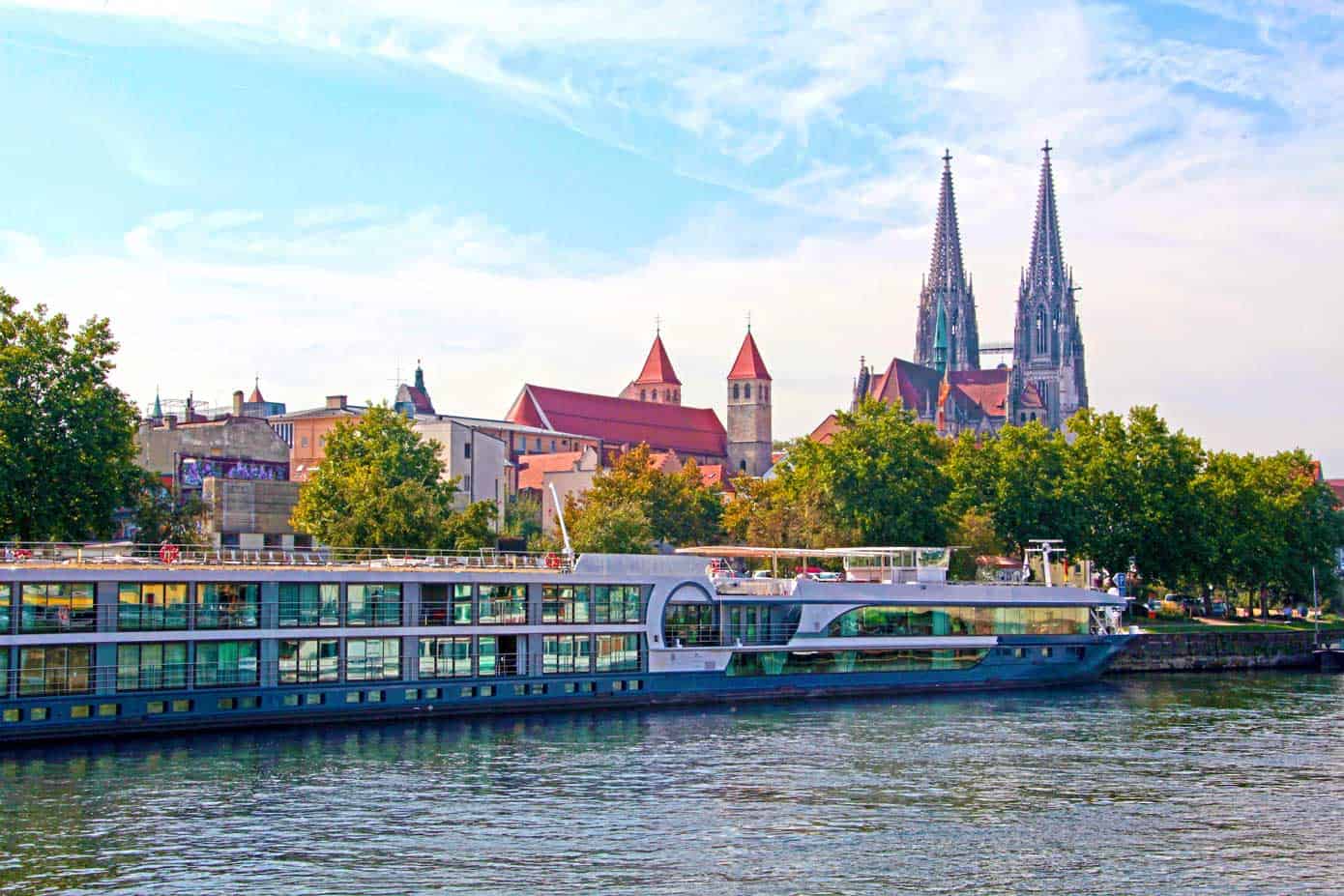 River cruise ship on the Danube River with a castle in the background.