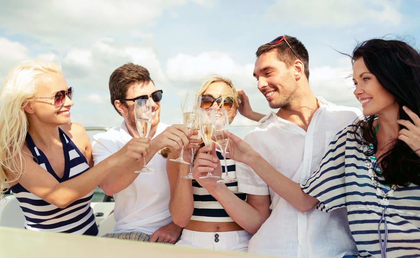 Group of adults celebrating and clinking glasses on a boat.