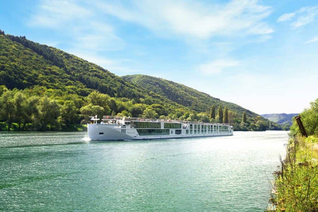 River cruise ship sailing on a river on a sunny day.