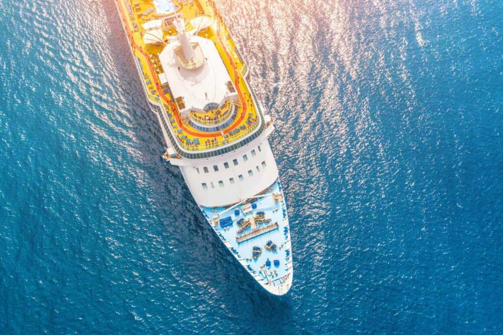 Aerial view of a cruise ship in a turquoise ocean.