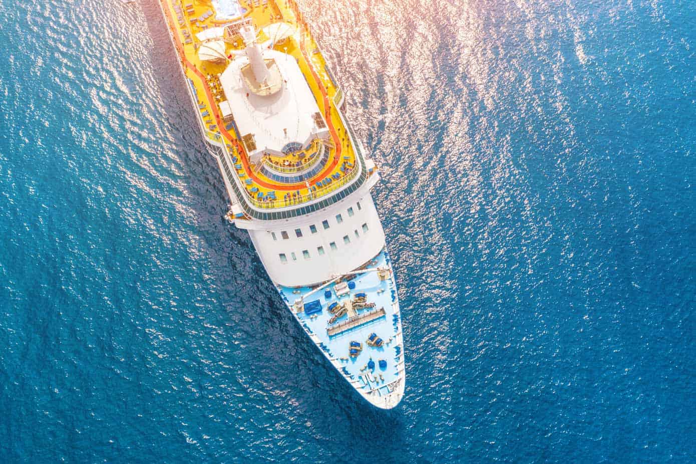 Specialty Cruises Aerial view of a cruise ship in a turquoise ocean.