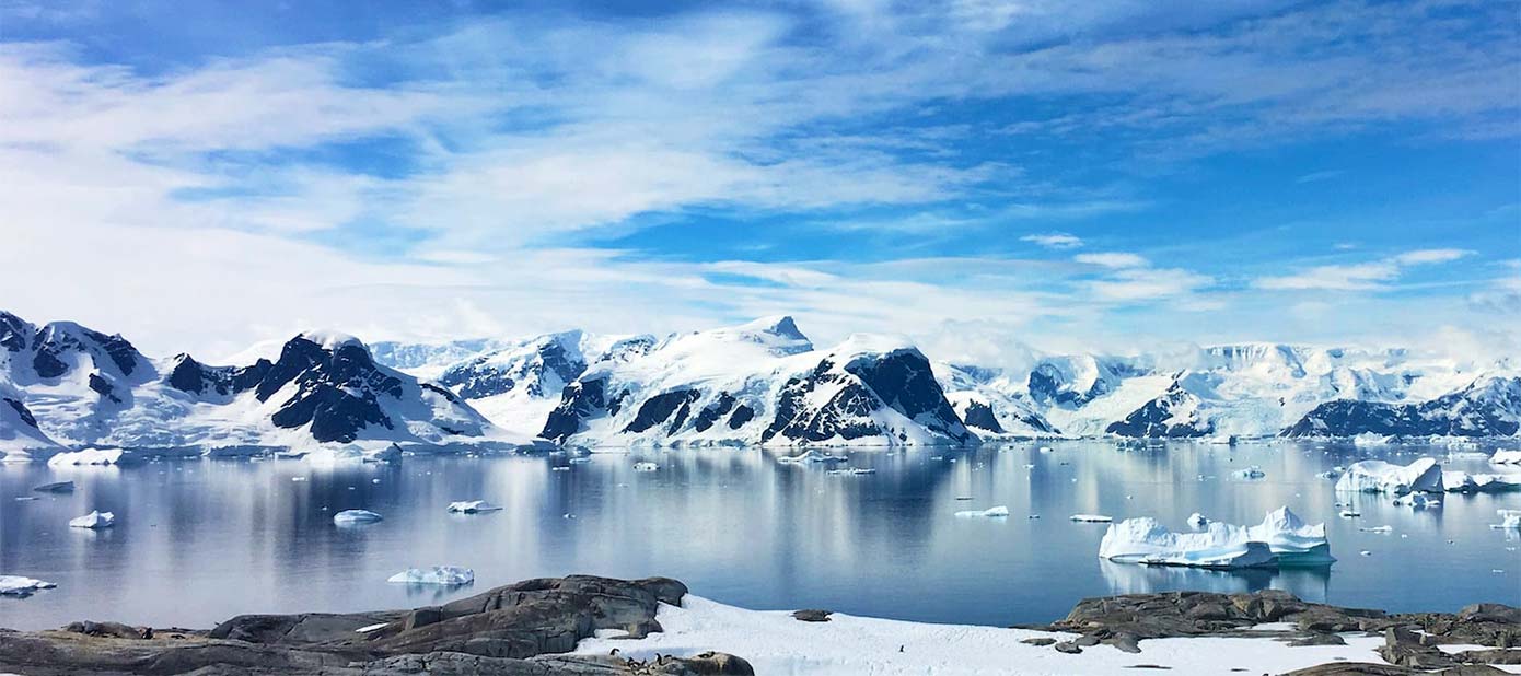 Snow capped mountains and icebergs in Antarctica.