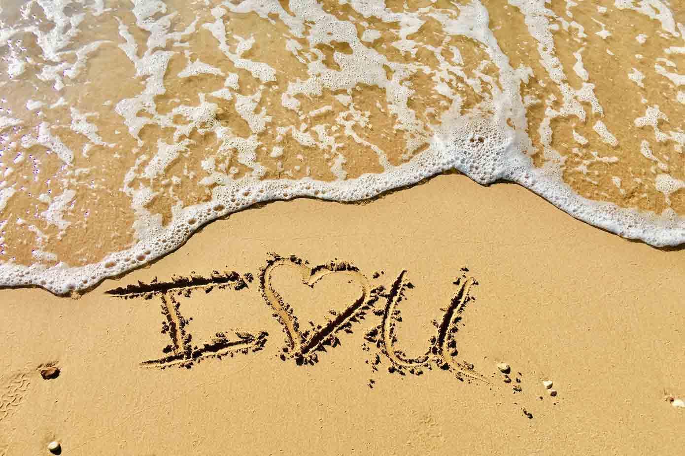 Best Honeymoon Cruises Heart drawn in the sand on a beach.
